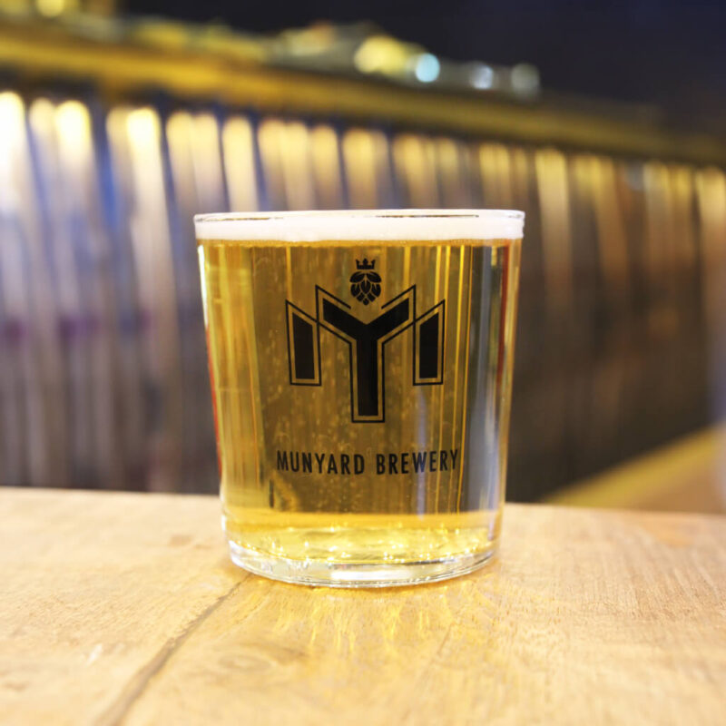 Branded half pint glass featuring Munyard Brewery logo